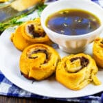 French Dip Pinwheels on a plate with a bowl of Au Jus.