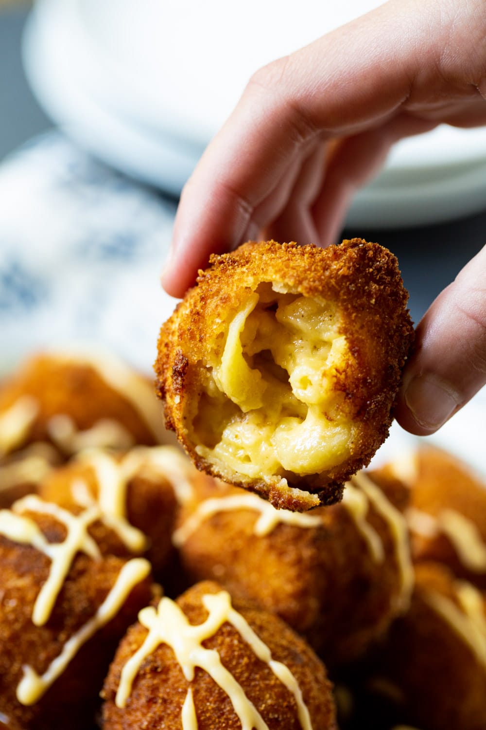Fried Mac and Cheese with a bite removed to show inside.