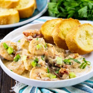 Garlic Shrimp with Creamy Parmesan Sauce with toasted baguette slices on a plate.