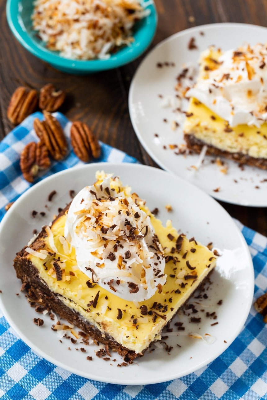 Overhead of 2 brownies topped with whipped cream, coconut, and chocolate shavings.