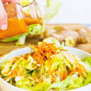 Pouring Dressing over salad.