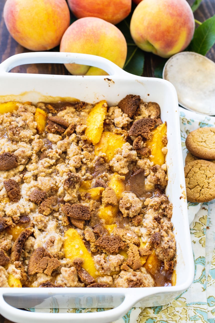 Peach Gingersnap Crisp with fresh peaches in background