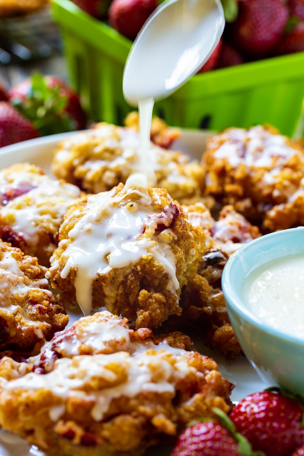 Spoon drizzling glaze on fritters.