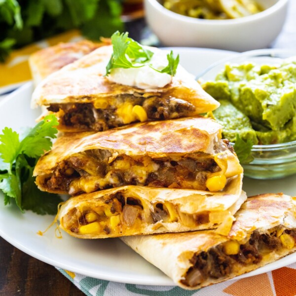 Ground Beef Quesadillas cut into wedges and piled on a plate.