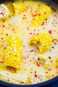 Southern Hot Honey Butter Corn in a large pot with milk, butter mixture.