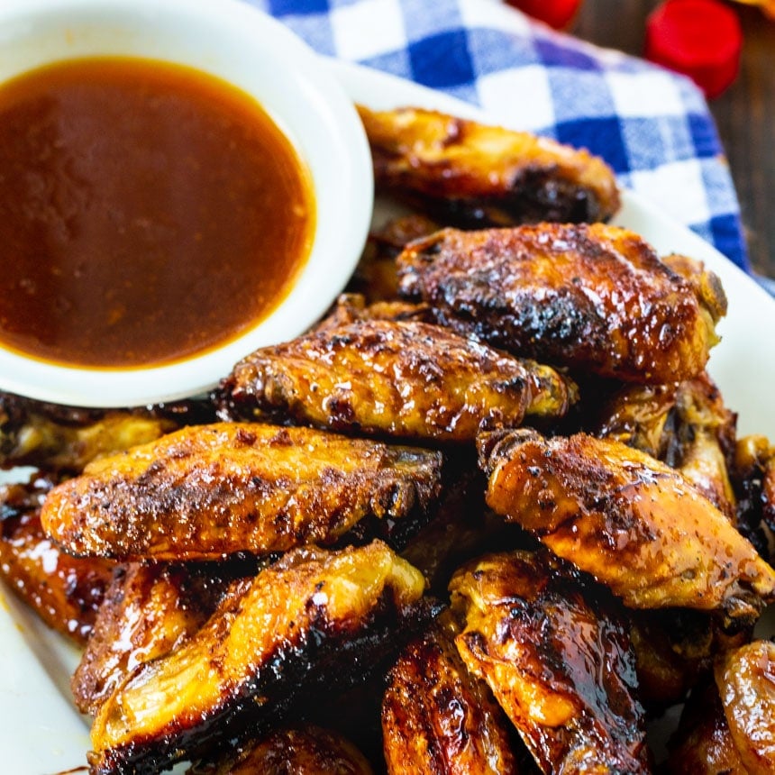 Wings on a plate with a bowl of glaze.