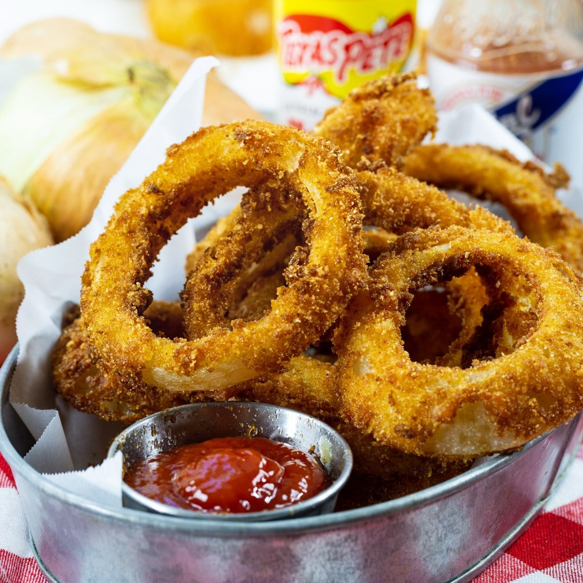 Hot Sauce Marinated Onion Rings in a serving dish with ketchup.