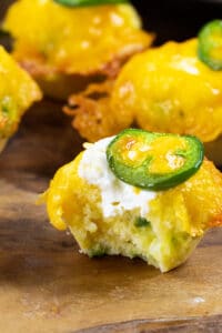 Jalapeno Popper Corn Muffins with bite taken out of one to show inside.