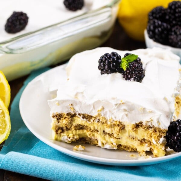 Slice of Lemon Icebox Cake topped with blackberries.