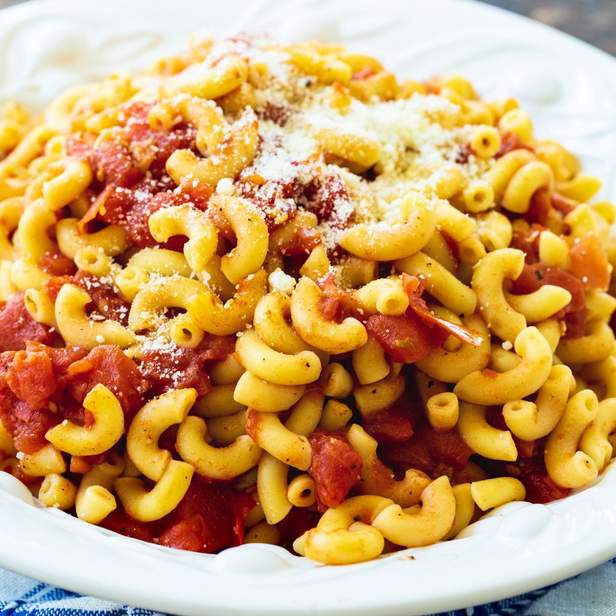 Macaroni and Tomatoes topped with Parmesan cheese in a bowl.