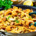 Pasta with shrimp and andouille in a skillet.