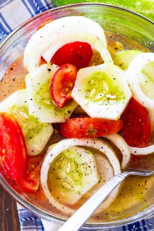 Marinated Cucumber, Tomato, and Onion Salad in a glass bowl.