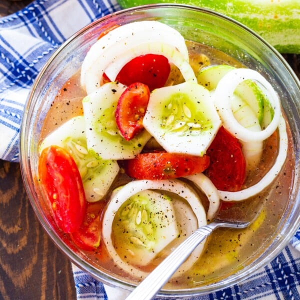 Marinated Cucumber, Tomato, and Onion Salad in a glass bowl.