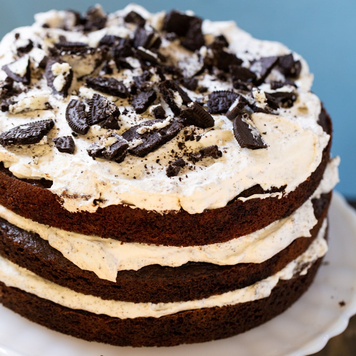 Mississippi Mudslide Cake topped with crushed oreos on a cake stand.