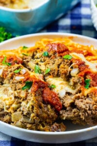 Two slices of Mozzarella Stuffed Meatloaf on plate with pasta.
