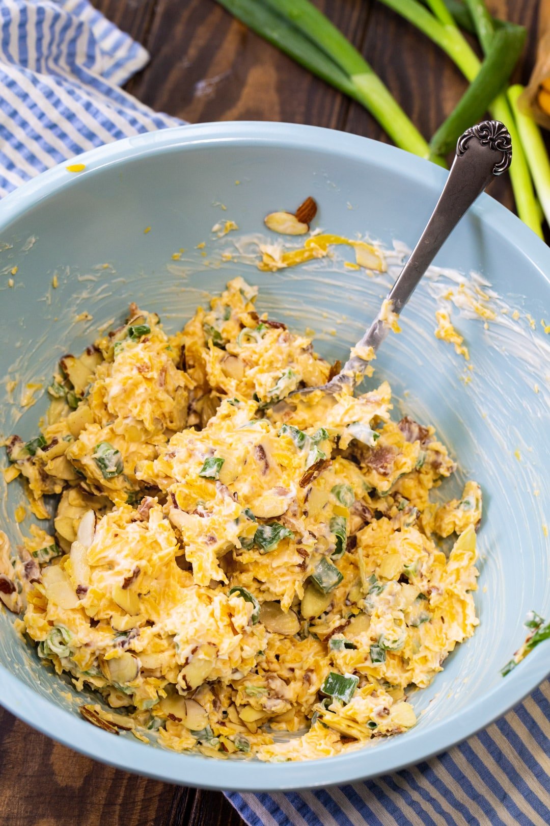 Dip being stirred together in a large blue mixing bowl.