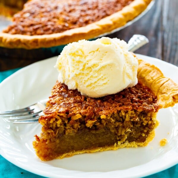 Slice of Oatmeal Pie topped with vanilla ice cream.