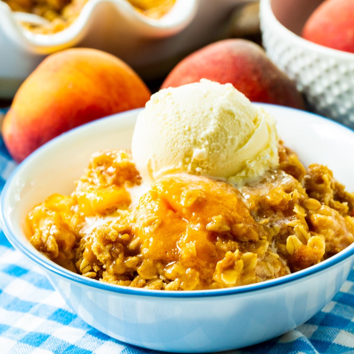 Peach Crisp topped with ice cream in a bowl.
