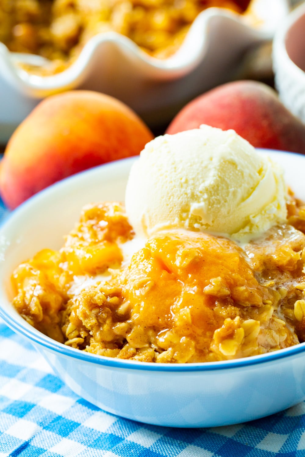 Peach Crisp topped with ice cream in a bowl.