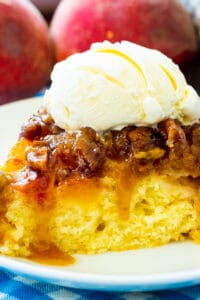 Slice of Peach Praline Upside Down Cake topped with ice cream.