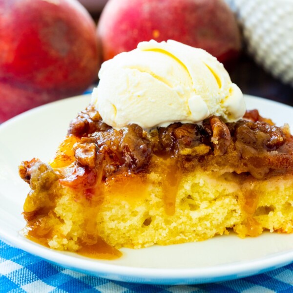 Slice of Peach Praline Upside Down Cake topped with ice cream.