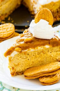 Slice of Peanut Butter Cheesecake on plate with Nutter Butter Cookies