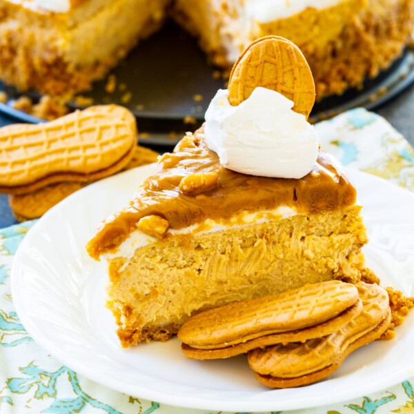 Slice of Peanut Butter Cheesecake on plate with Nutter Butter Cookies