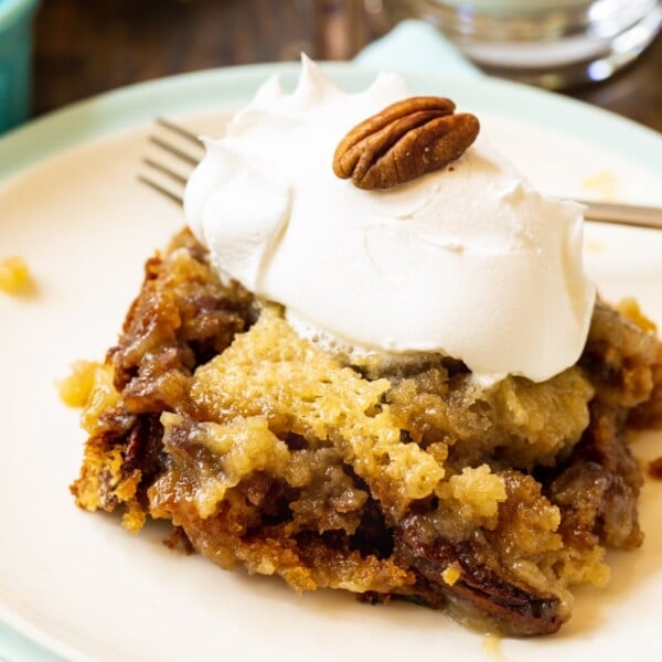 Slice of Pecan Pie Cake topped with whipped cream.