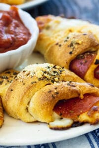 Pepperoni Crescent Rolls on a plate with bowl of marinara.