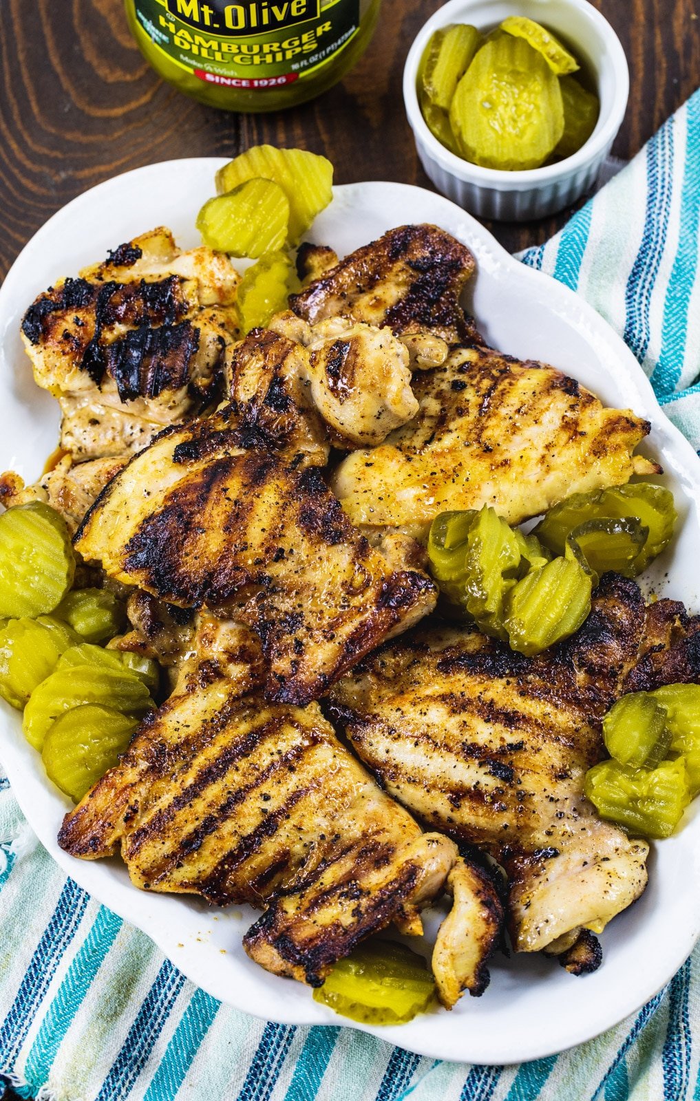 Grilled Chicken on serving platter with pickle chips.
