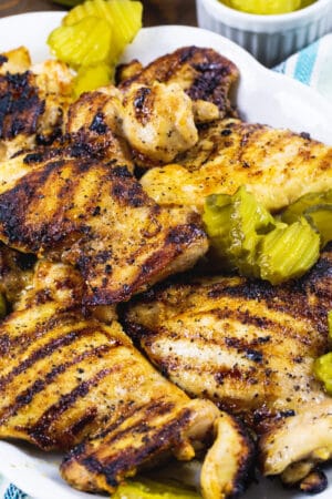 Pickle-Brined Grilled Chicken on a serving platter with pickle chips.