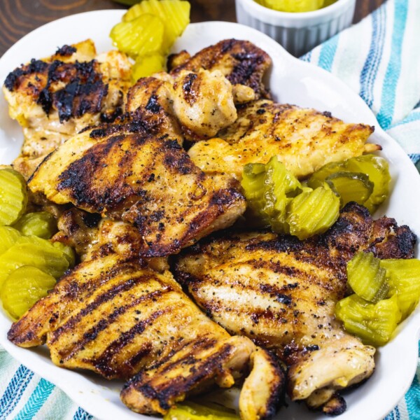 Pickle-Brined Grilled Chicken on a serving platter with pickle chips.