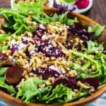 Pickled Beets Salad with Walnuts and Feta in a wooden bowl.