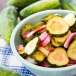 Pickled Cucumber slices and onion in a bowl.
