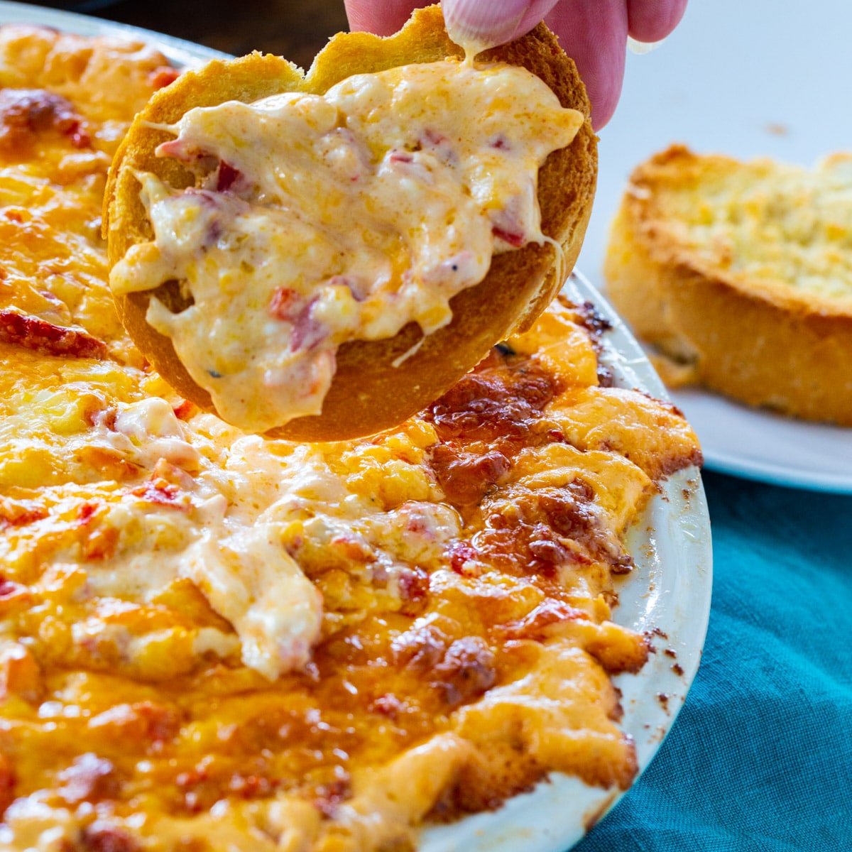 Baked Pimento Cheese Dip on a piece of toasted baguette.