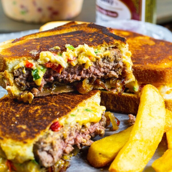 Patty Melt cut in half with fries.