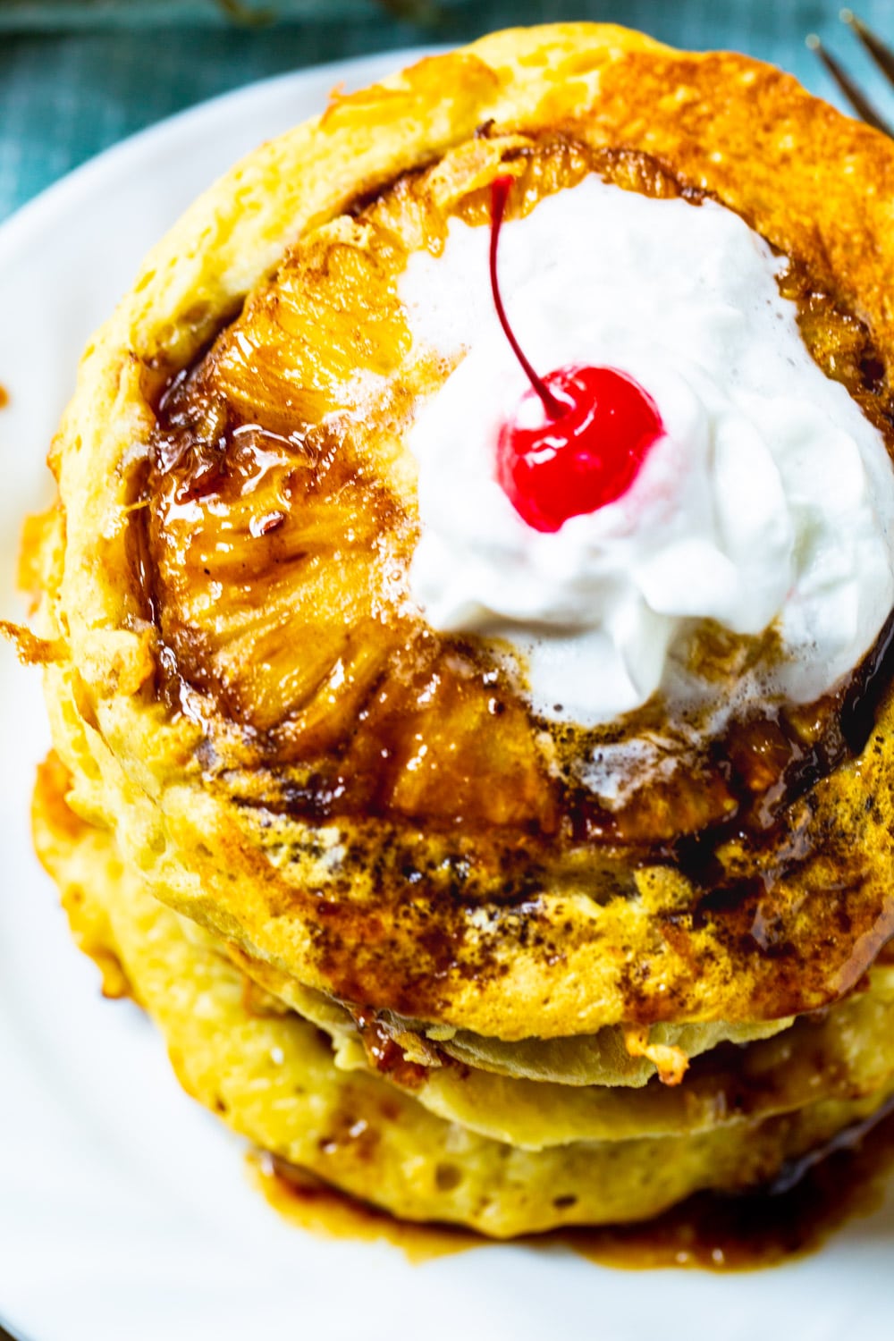 Stack of Pineapple Upside Down Pancakes with cherry on top.