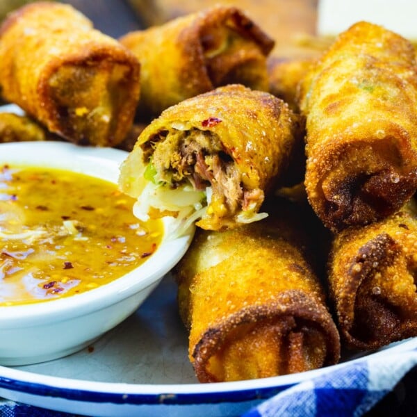 Pulled Pork Egg Rolls in serving tray with peach dipping sauce.