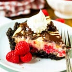 Slice of Raspberry Cream Cheese Pie on a plate with raspberries.