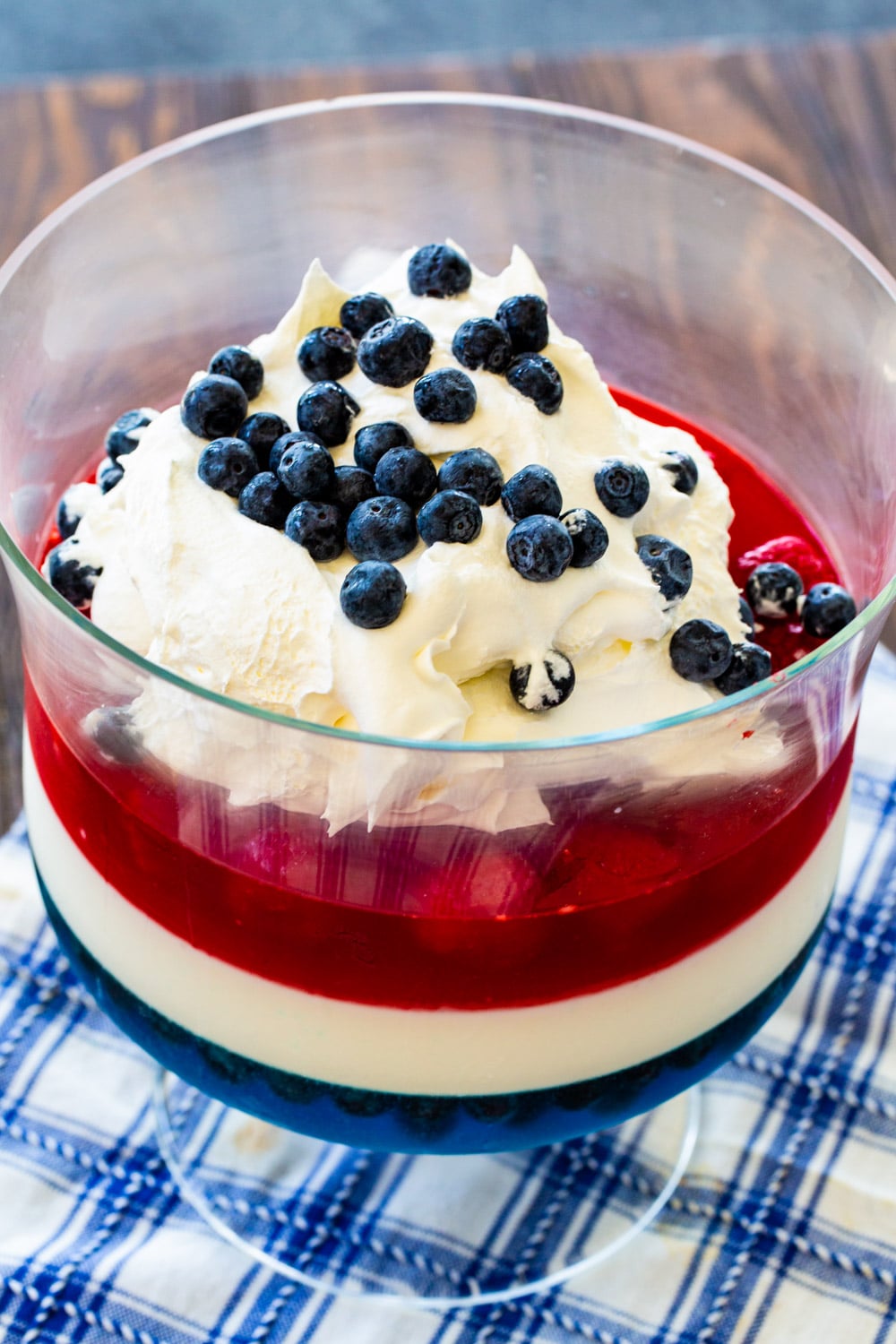 Red, White & Blue Jello Salad in trifle bowl topped with whipped cream.