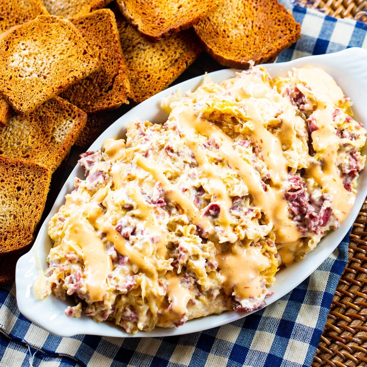 Slow Cooker Reuben Dip in a serving dish with toasted bread slices.