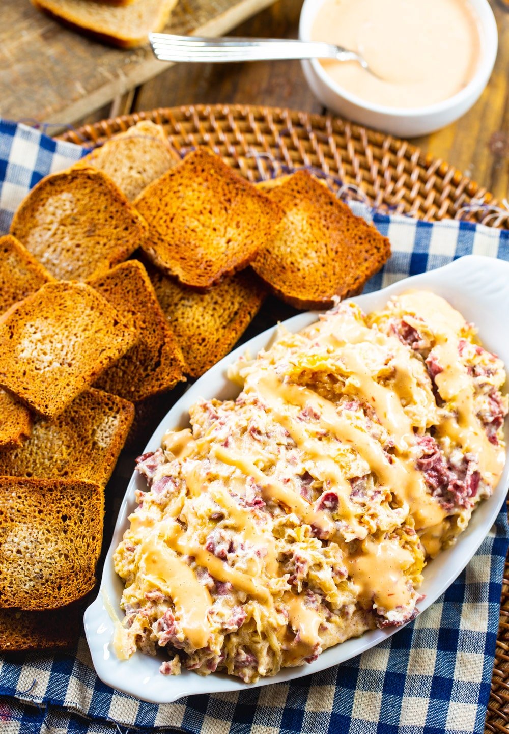 Slow Cooker Reuben Dip in a serving dish with toasted mini bread slices.