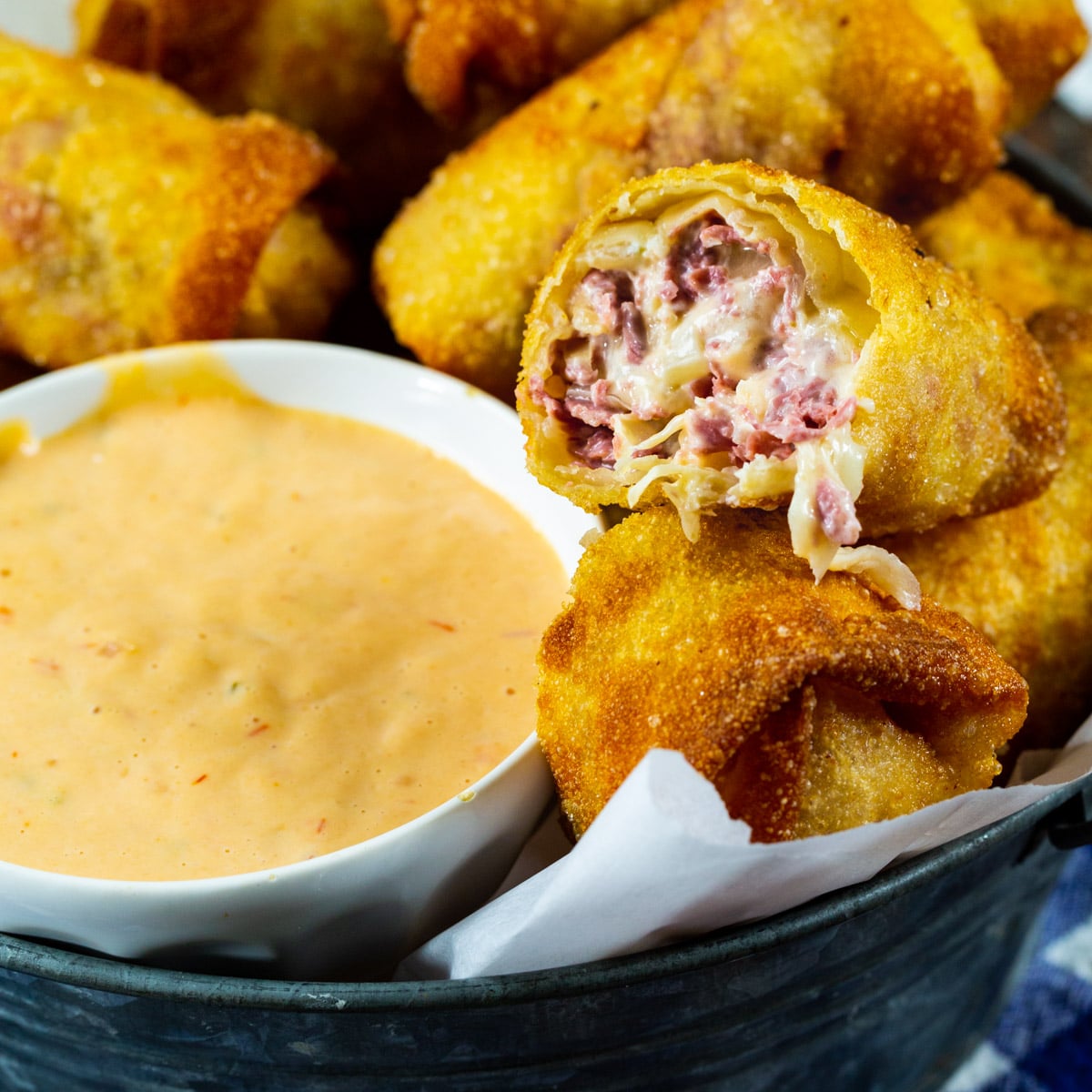 Reuben Egg Rolls with bowl full of Thousand Island Dressing.