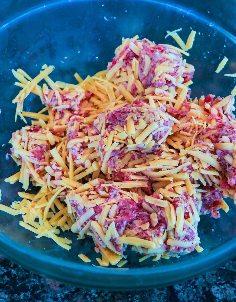 Sausage and shredded cheddar in a large bowl.