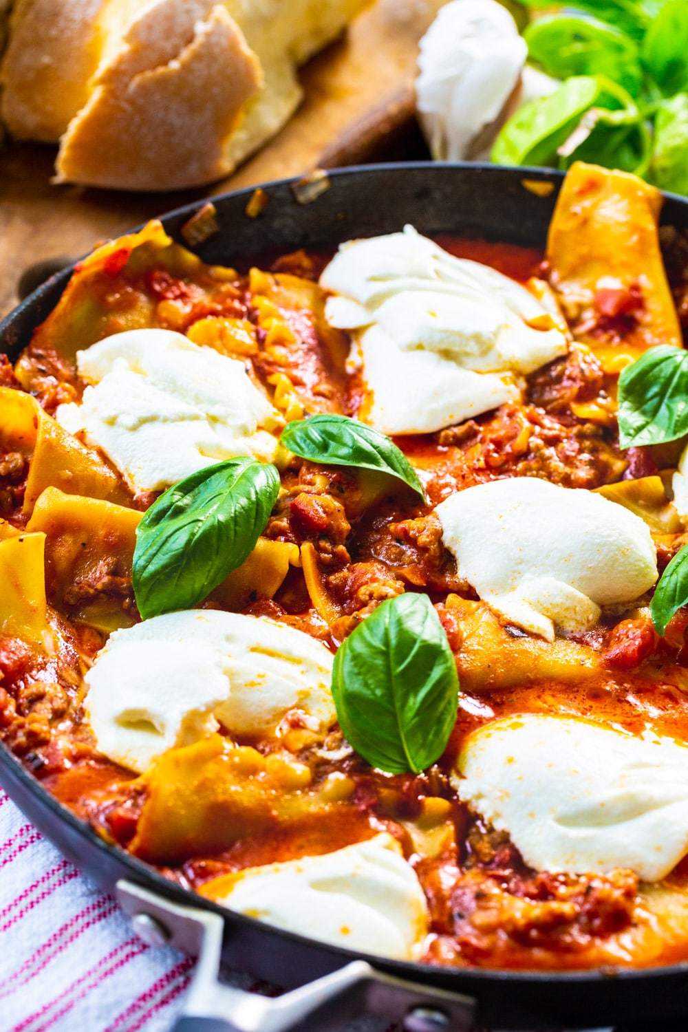 Skillet Lasagna in skillet with bread in background.