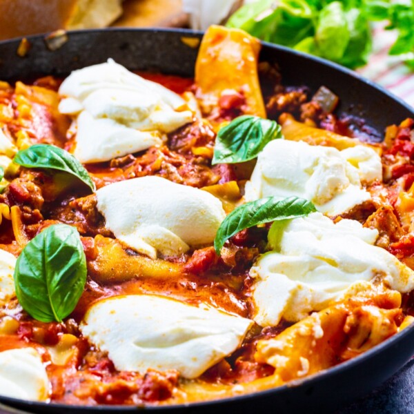 Skillet Lasagna in skillet topped with fresh basil.