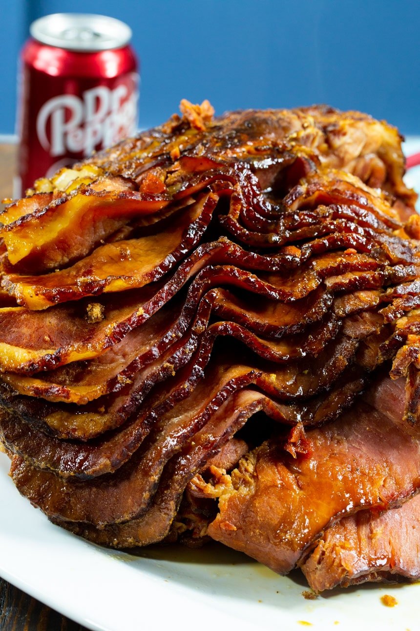 Sliced ham on a serving platter with a can of Dr. Pepper.