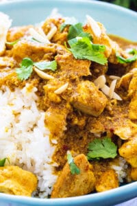 Slow Cooker Chicken Korma over rice in a blue bowl.
