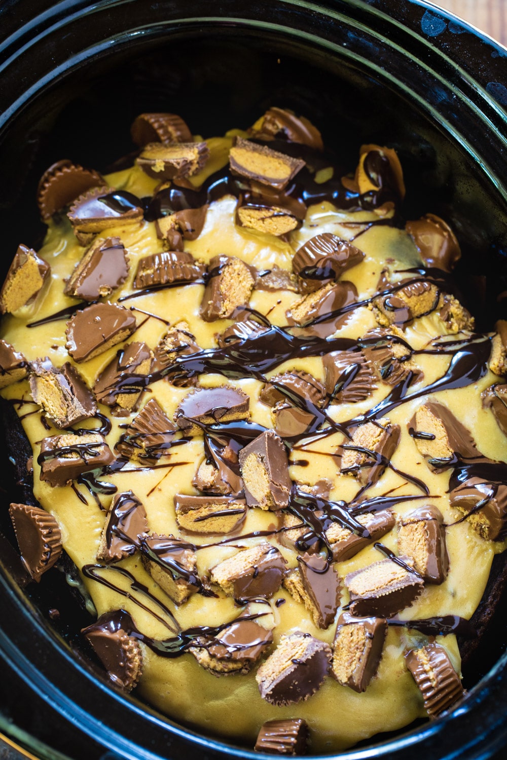 Slow Cooker Chocolate Peanut Butter Cake  topped with chopped peanut butter cups.