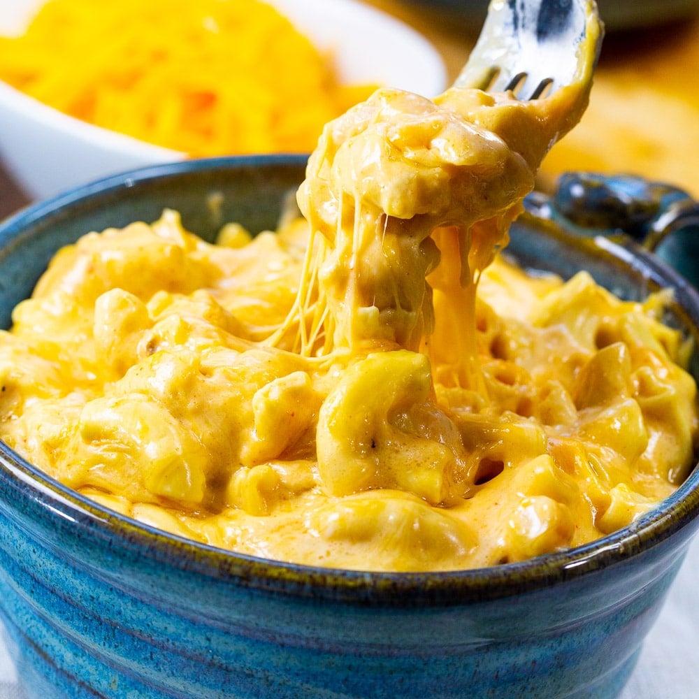 A fork scooping up Slow Cooker Ultra Creamy Mac and Cheese.